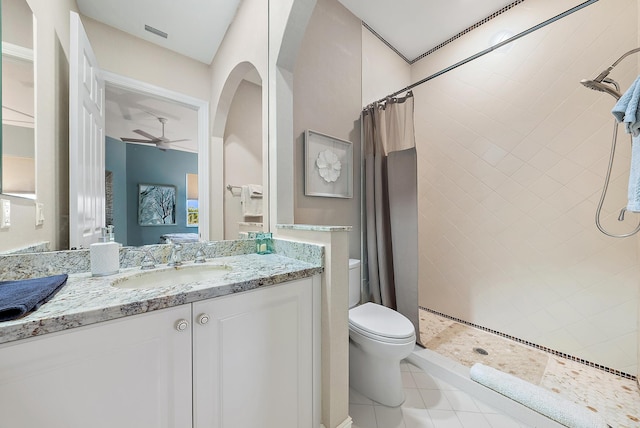 bathroom featuring ceiling fan, a shower with curtain, tile patterned flooring, toilet, and vanity