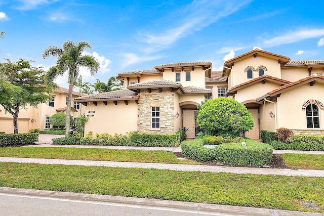 mediterranean / spanish home with a front lawn