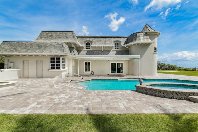 477 S Beach Rd, Jupiter Island, FL 33455 - rear view of house with a high end roof, a patio area, stucco siding, mansard roof, and a pool with connected hot tub
