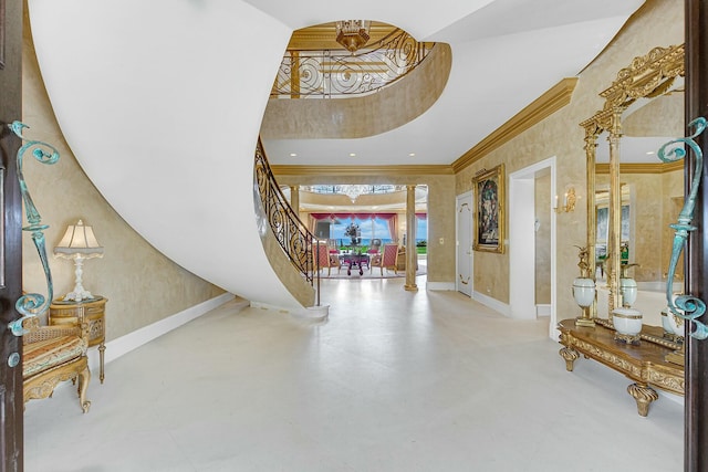 foyer with decorative columns and crown molding