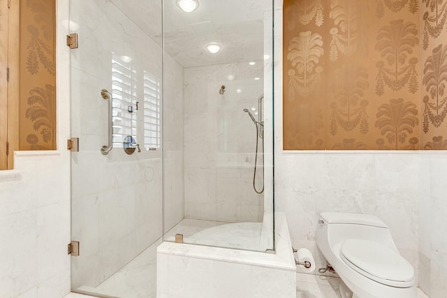 bathroom with toilet, a shower with door, and tile walls