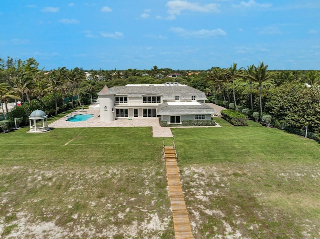 477 S Beach Rd, Jupiter Island, FL 33455 - rear view of property with a yard, an outdoor pool, and a patio