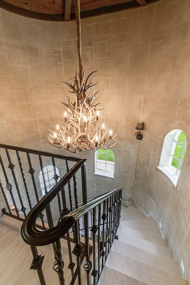 staircase with tile patterned flooring, tile walls, and a chandelier