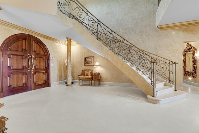 foyer featuring a high ceiling and ornate columns