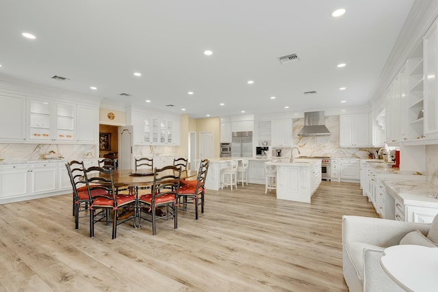 dining room featuring sink, light hardwood / wood-style flooring, and ornamental molding