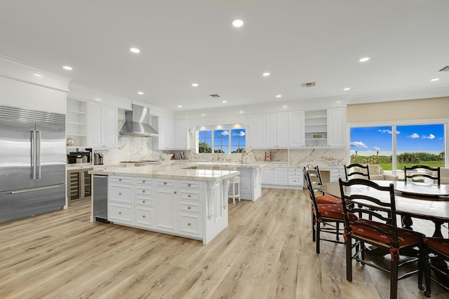 477 S Beach Rd, Jupiter Island, FL 33455 - kitchen featuring open shelves, stainless steel built in refrigerator, wall chimney range hood, a center island, and ornamental molding