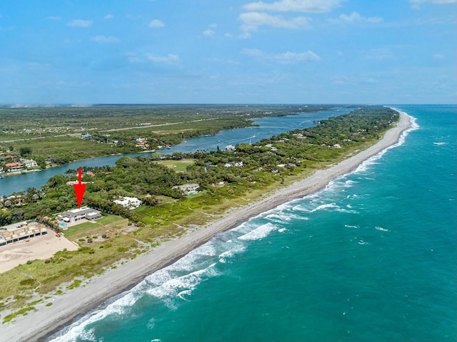 birds eye view of property featuring a beach view and a water view