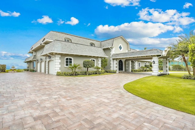 477 S Beach Rd, Jupiter Island, FL 33455 - view of property featuring decorative driveway, mansard roof, a front yard, and a shingled roof