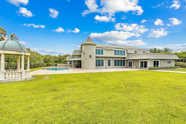 back of property with a lawn, a patio area, and a gazebo