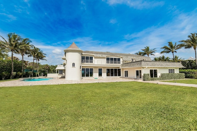 rear view of house with a lawn and a patio