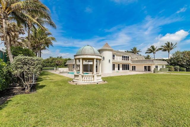 back of house with a lawn and a patio