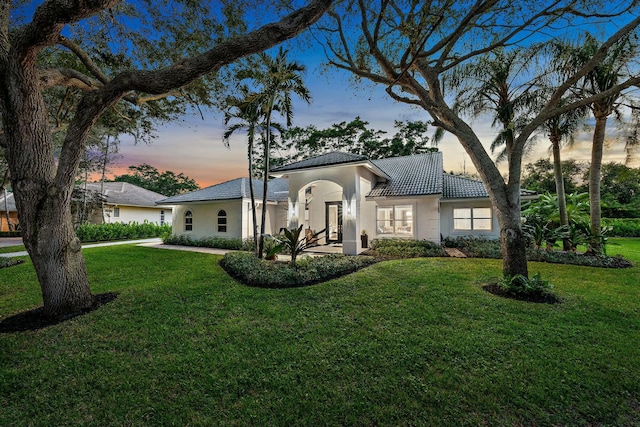 mediterranean / spanish home with a lawn