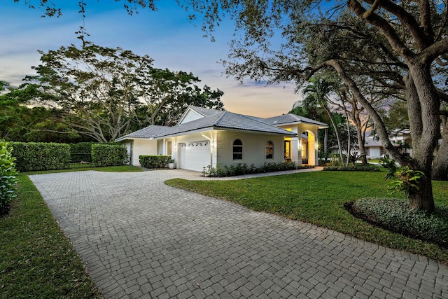 ranch-style home with a yard and a garage