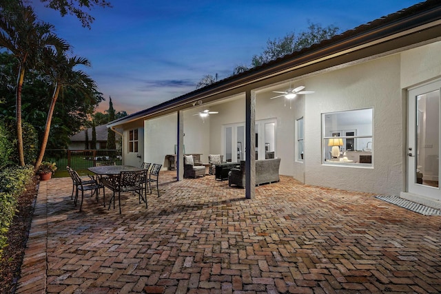 patio terrace at dusk featuring outdoor lounge area and ceiling fan