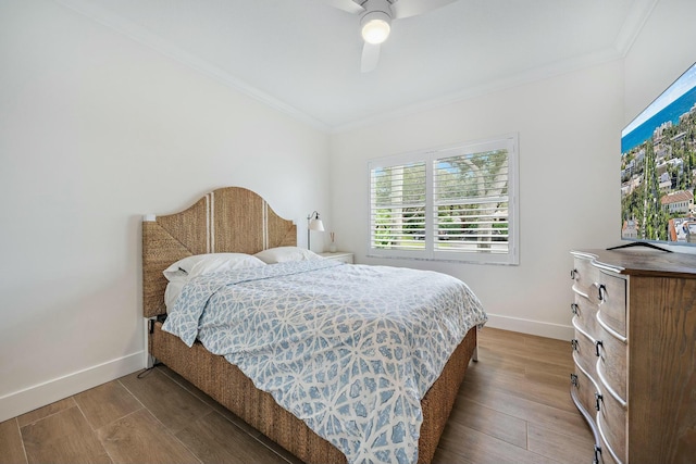 bedroom featuring ceiling fan, crown molding, and hardwood / wood-style flooring