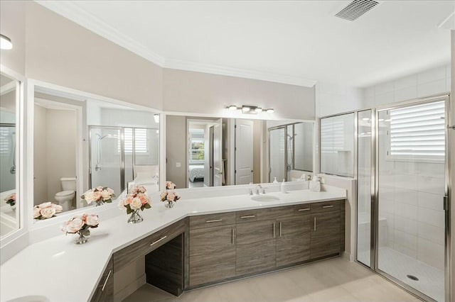 bathroom with ornamental molding, vanity, a healthy amount of sunlight, and toilet