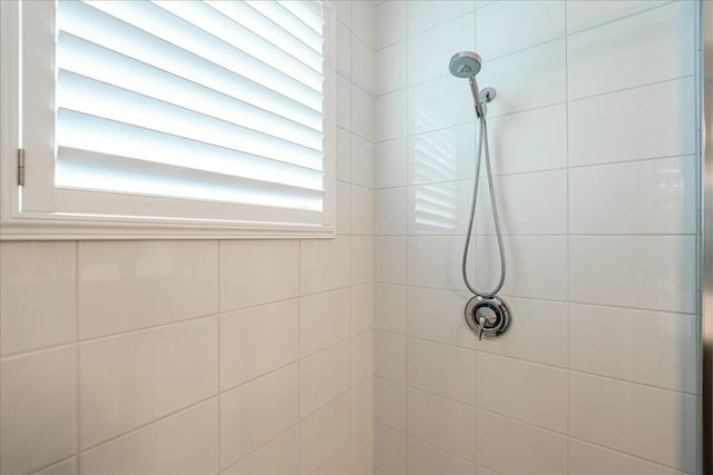 bathroom featuring tiled shower and a wealth of natural light