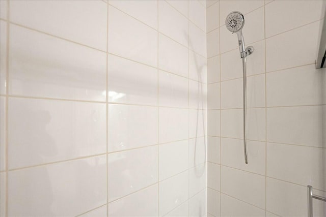 interior details featuring tiled shower