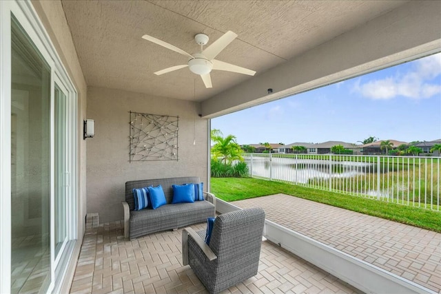 view of patio / terrace featuring a water view and ceiling fan