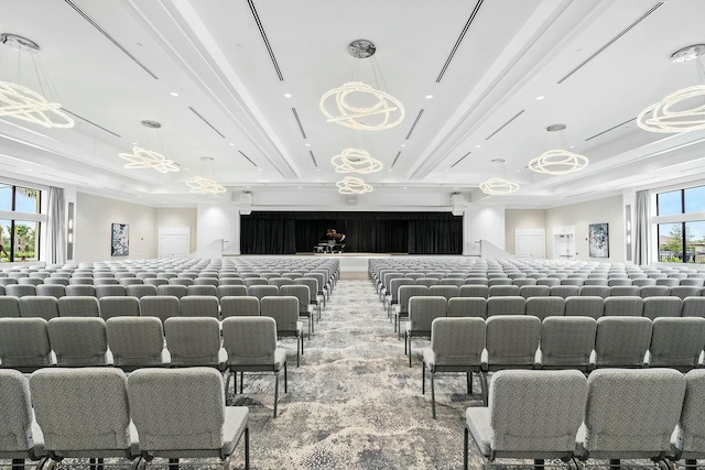 bedroom with a tray ceiling, multiple windows, and light colored carpet