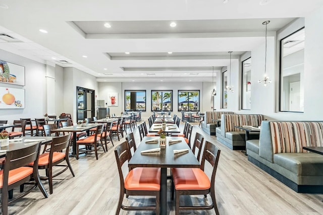 dining room with light hardwood / wood-style floors and a tray ceiling