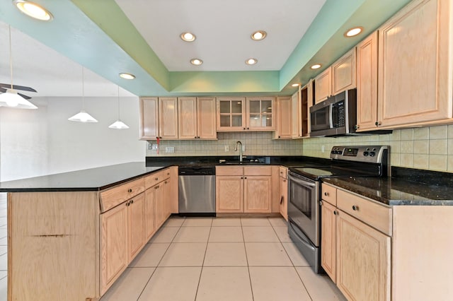 kitchen with appliances with stainless steel finishes, decorative light fixtures, light brown cabinetry, sink, and kitchen peninsula