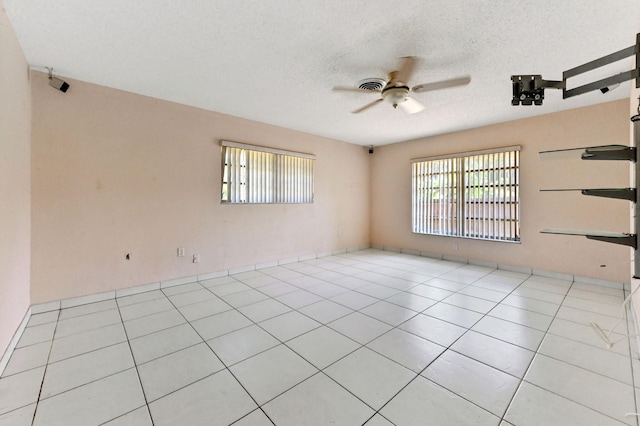 unfurnished room featuring ceiling fan, a textured ceiling, and light tile patterned floors