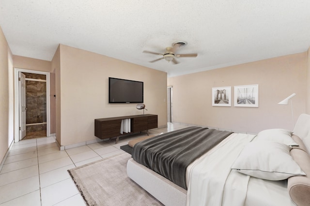 tiled bedroom featuring a textured ceiling, ensuite bath, and ceiling fan