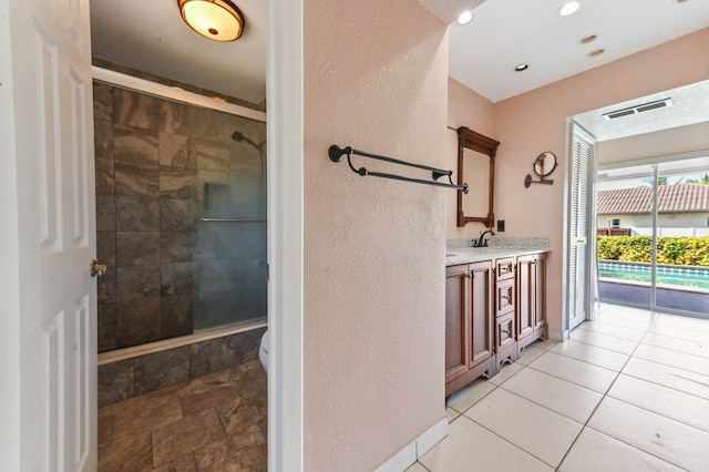 bathroom featuring toilet, walk in shower, tile patterned floors, and vanity