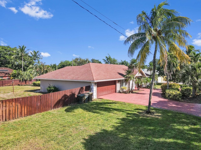 ranch-style house featuring a garage and a front yard