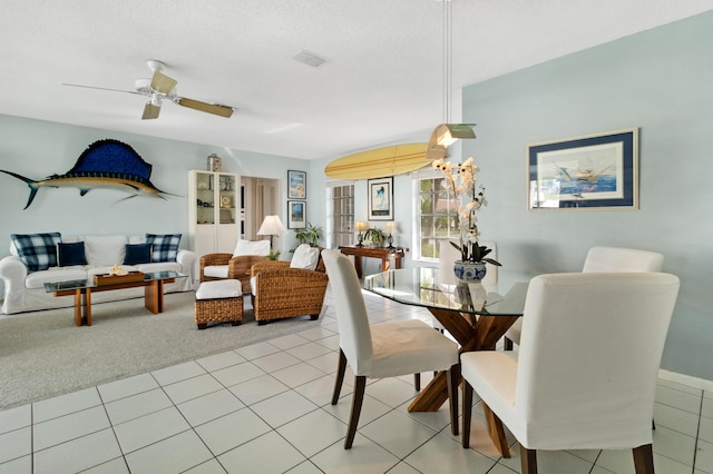 dining room with a textured ceiling, ceiling fan, and light tile patterned flooring