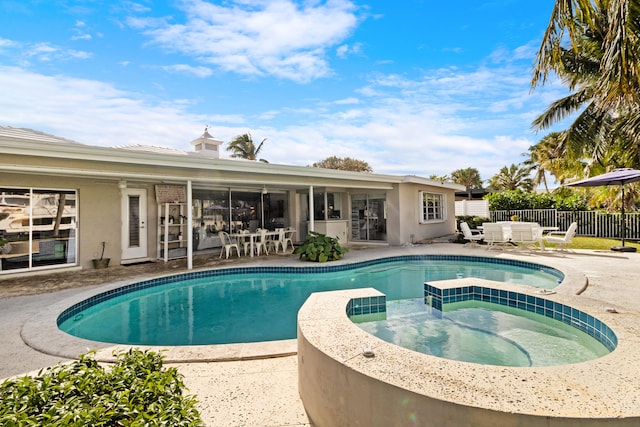 view of swimming pool featuring a patio area and an in ground hot tub