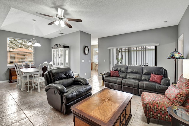 living room with ceiling fan with notable chandelier, a textured ceiling, and a healthy amount of sunlight