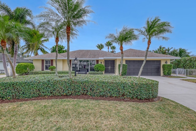 ranch-style home featuring a garage and a front lawn