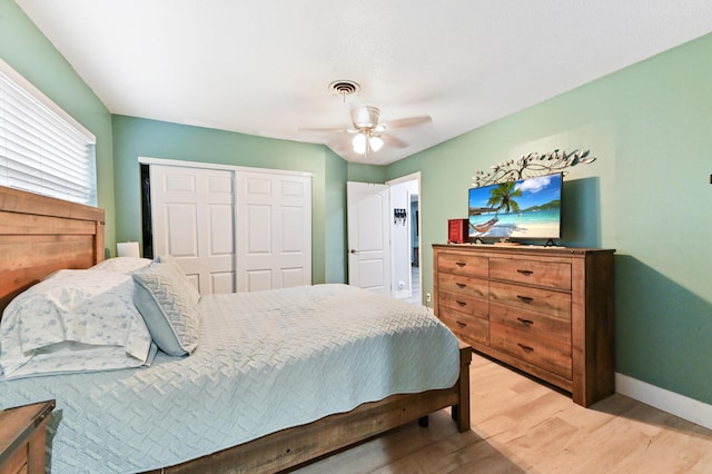 bedroom with hardwood / wood-style floors, ceiling fan, and a closet