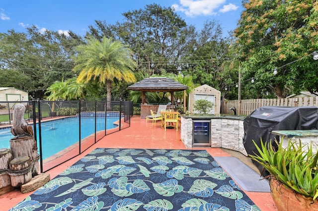 view of swimming pool with an outdoor bar, a shed, a gazebo, a patio area, and grilling area