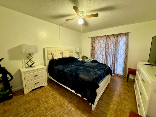 bedroom with a textured ceiling, light parquet floors, and ceiling fan