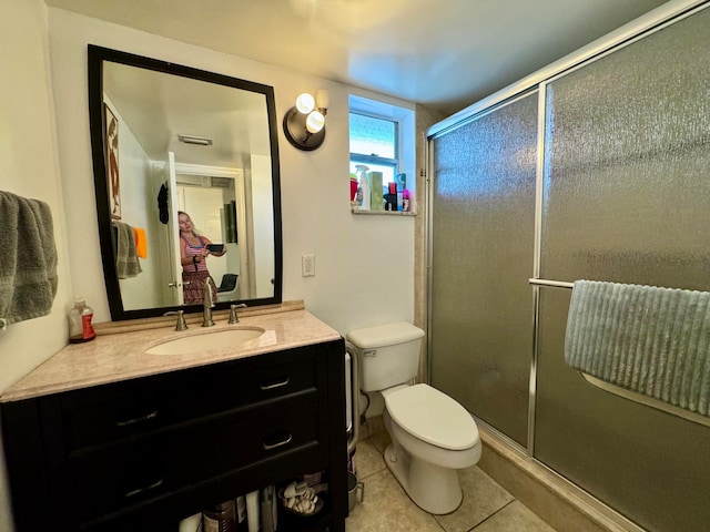 bathroom with toilet, tile patterned flooring, vanity, and walk in shower