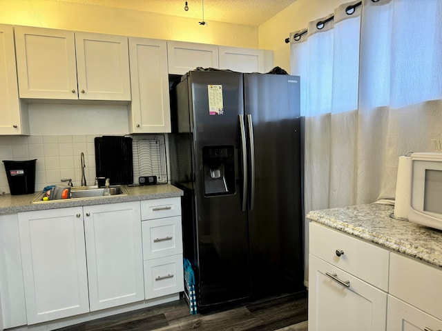 kitchen with white cabinets, dark hardwood / wood-style floors, sink, and black refrigerator with ice dispenser