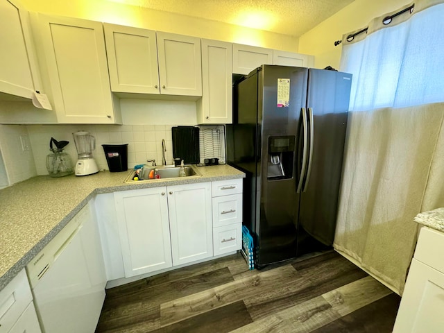 kitchen with dark hardwood / wood-style floors, black fridge, and white cabinetry