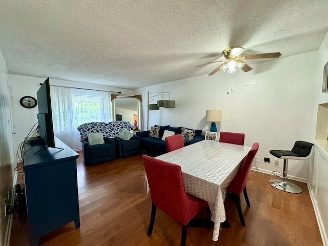 dining area with dark hardwood / wood-style floors, ceiling fan, and a textured ceiling