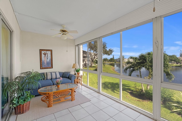 sunroom / solarium with ceiling fan and a water view