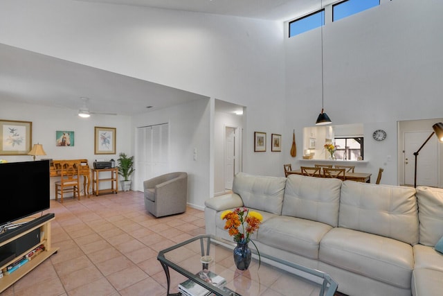 living room featuring light tile patterned floors, a towering ceiling, and ceiling fan