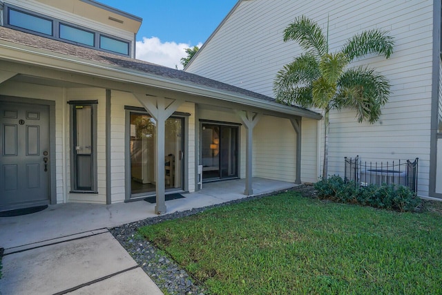 property entrance with a patio area and a yard