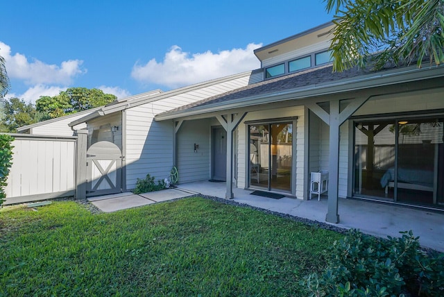 back of house featuring a lawn and a patio