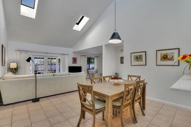 dining space with a skylight, french doors, high vaulted ceiling, and light tile patterned floors