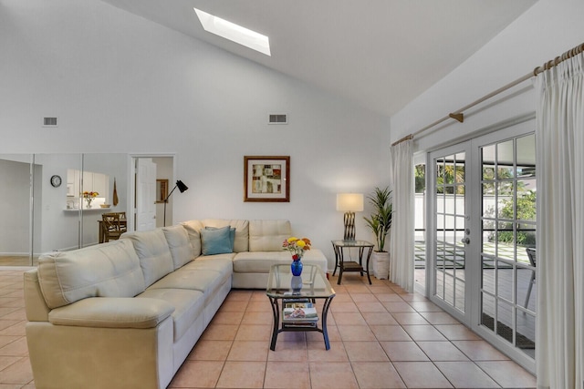 living room featuring a skylight, french doors, high vaulted ceiling, and light tile patterned floors