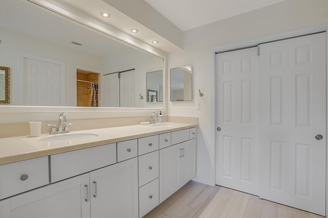 bathroom featuring wood-type flooring, vanity, and walk in shower