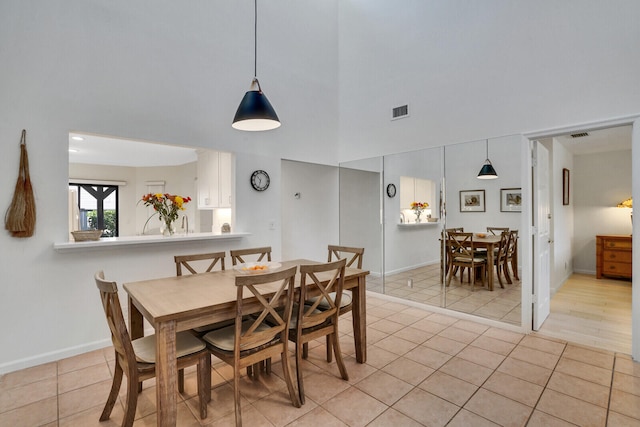 tiled dining space with a high ceiling