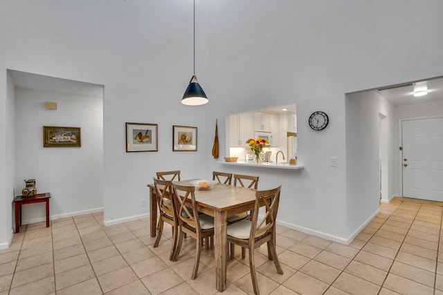 dining area with light tile patterned floors and a high ceiling